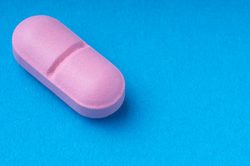 pink pills on a blue background. omega3. vitamins.