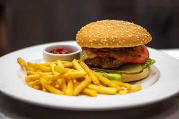 fresh tasty burger and french fries on wooden table