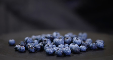 A lot of blueberries closeup on a black background.