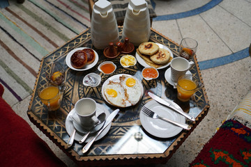 Breakfast with eggs, fresh orange juice, green tea, pancakes, butter, honey and chocolate mousse.