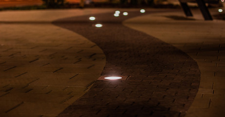 soft focus twilight city street urban photography of paved road and ground lamp illumination 