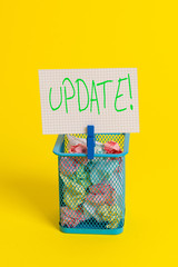 Obraz premium Text sign showing UPDATE. Business photo showcasing make something more modern or up to date like software program Trash bin crumpled paper clothespin empty reminder office supplies yellow