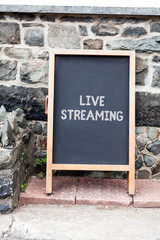 Handwriting text writing Live Streaming. Conceptual photo Transmit live video coverage of an event over the Internet Empty black board with copy space for advertising. Blank dark board
