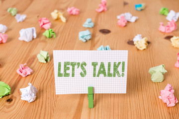 Conceptual hand writing showing Let S Talk. Concept meaning they are suggesting beginning conversation on specific topic Colored crumpled papers wooden floor background clothespin