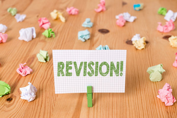 Conceptual hand writing showing Revision. Concept meaning action of revising over someone like auditing or accounting Colored crumpled papers wooden floor background clothespin
