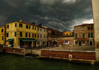 VENICE, ITALY - JULY,5: Stormy day in the center of Venice, boats, buildings, bridges under the heavy clouds
