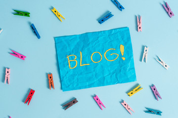 Word writing text Blog. Business photo showcasing regularly updated website web page run by individual or group Colored clothespin rectangle shaped reminder paper light blue background