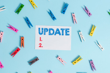 Handwriting text writing UPDATE. Conceptual photo make something more modern or up to date like software program Colored clothespin rectangle shaped reminder paper light blue background