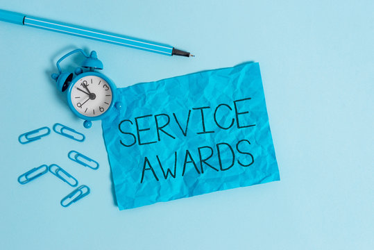 Word writing text Service Awards. Business photo showcasing Recognizing an employee for his or her longevity or tenure Metal alarm clock blank crushed sheet marker clips sky colored background
