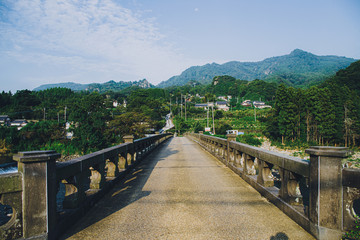 Fototapeta premium Old stone bridge seen from the street of the country