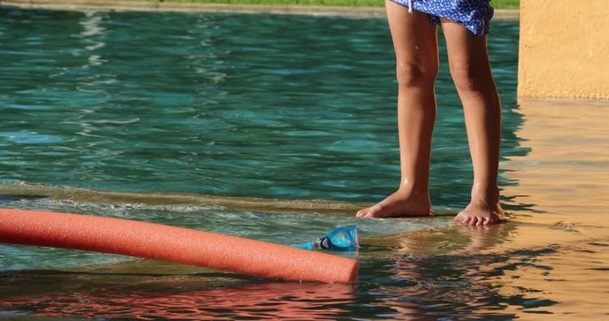 Small boy legs standing by the poolside swimming pool