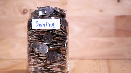 Close up save coin in the bottle glass on wood background (Thai currency, THB coin)