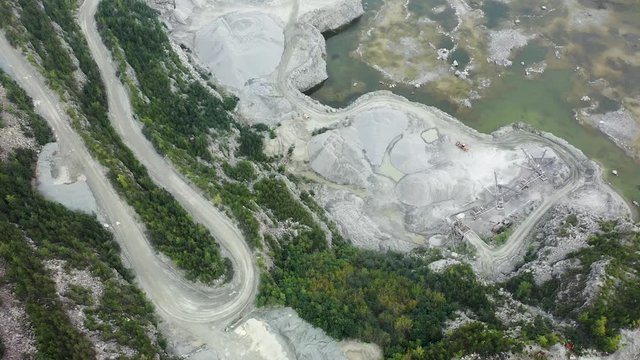 Big yellow heavy truck in open cast mine mining of coal the overall plan. Open pit anthracite mining, mining truck at work working in quarry. 4K footage from drone