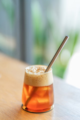 Sparkling Raspberry iced Americano on wooden background with natural window light.