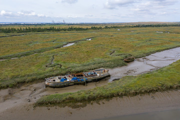 Fototapeta premium Aerial view of an abandoned boat on Benfleet marshes mudflats, Essex, England