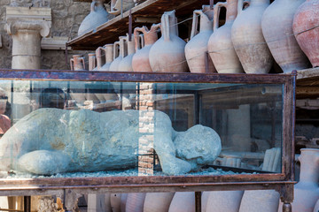 Plaster cast of an inhabitant and artifacts in the Forum Granary of the ancient city of Pompeii