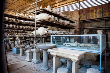 Plaster cast of a child and artifacts in the Forum Granary of the ancient city of Pompeii - obrazy, fototapety, plakaty