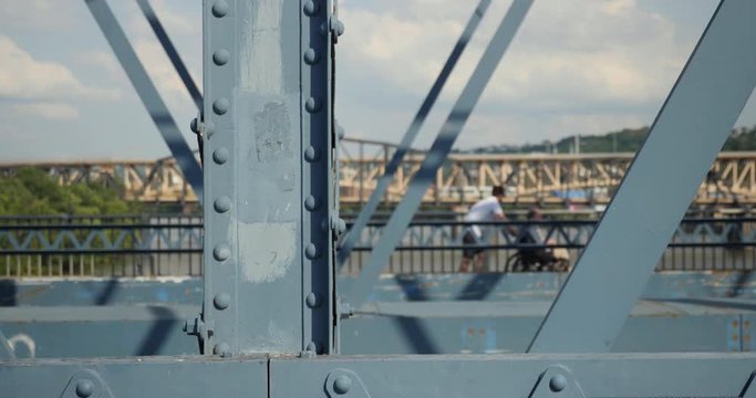 A daytime profile view of pedestrians and traffic on the Smithfield Street Bridge in downtown Pittsburgh, Pennsylvania on a sunny summer day.  	