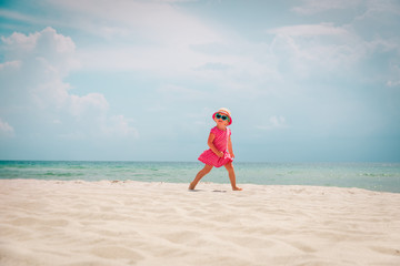 happy cute little girl run on sand beach