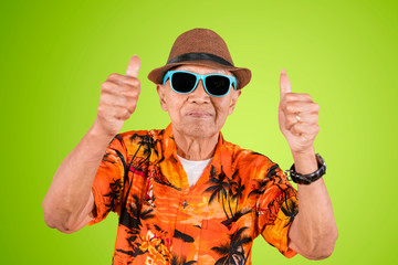 Senior male tourist showing thumbs up on studio