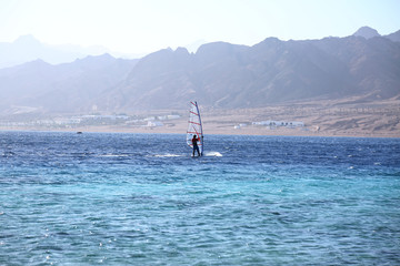 Windsurfer on Sea Shore against Cloudy Sky Outdoors