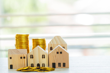 Home real estate mortgage concept : House Miniature model with stack money coins show for selling....