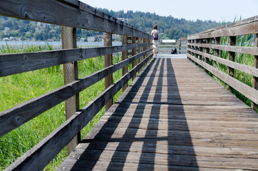 Woman wih a backpack walking on a bridge near Juanita Bay