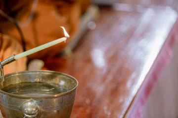 Buddha monk hold candlestick above holy water bowl. religion ceremony. Buddhist holy water. image for copy space.