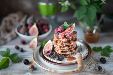 Chocolate waffles with figs, blackberries, raspberries and caramel sauce on top and mint