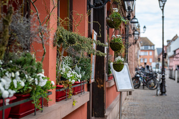 Fototapeta na wymiar Traditional cityscape, restaurant entrance with floral decoration in Colmar, France