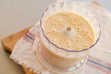 Blender bowl with whipped dough for healthy pancakes on wooden cutting board , eating healthy concept
