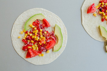 Mexican tacos with vegetarian fillings on light table, cooking process