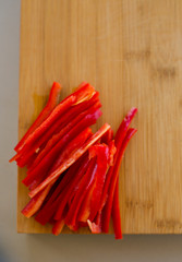 Fresh red hot chili peppers on wooden cutting board , close-up