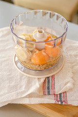 Blender bowl with eggs and banana slices with cereals, eating healthy concept