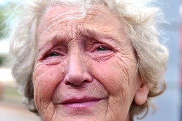 An old woman crying frantically. Tears in the eyes of an old wrinkled grandmother. Pain,...