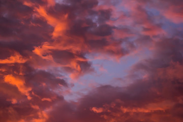 The bright orange sun rises against the backdrop of purple clouds
