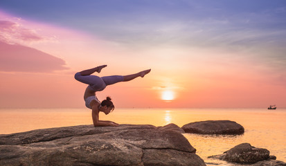 Asian girl practice Yoga on the beach Sunrise morning day