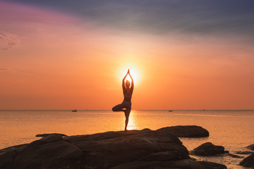 Asian girl practice Yoga on the beach Sunrise morning day