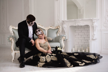 Couple with dark skull makeup on white background. Halloween