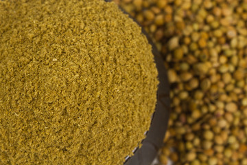 coriander powder with coriander seeds isolated on white background