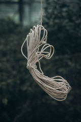 coiled rope hanging behind glass, background, selective focus, film and grain photo
