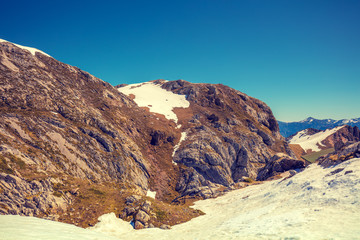 Obraz premium The top of the mountain, covered in snow in the summer. Mountain landscape on a sunny day. Beautiful nature, snowy landscape. Fuente De, Spain