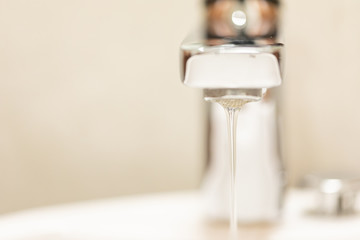 A drop of water dripping from the tap.