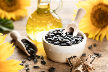 Sunflower oil in a bottle glass with seeds and flowers of sunflower. on blurred background