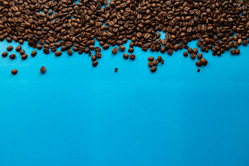 Roasted coffee beans with a blue background.