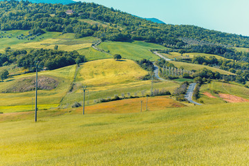 Fototapeta premium Beautiful landscape, spring nature. Mountain landscape. Top view of sunny fields on the hills in Tuscany, Italy