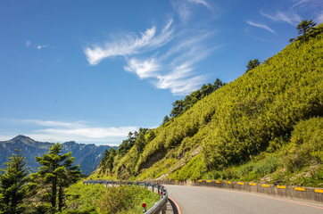 road with green grassland under blue sky