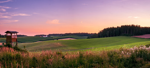 Observation stand for hunting during Bavarian Sunset in purple and rosa colors