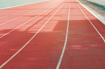Fototapeta premium running track red outdoor with white lines and morning sunlight