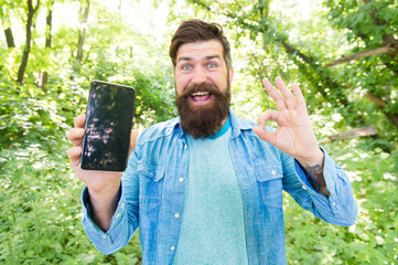 perfect device. happy bearded man show ok at phone. Mature hipster with beard. got lost in forest....